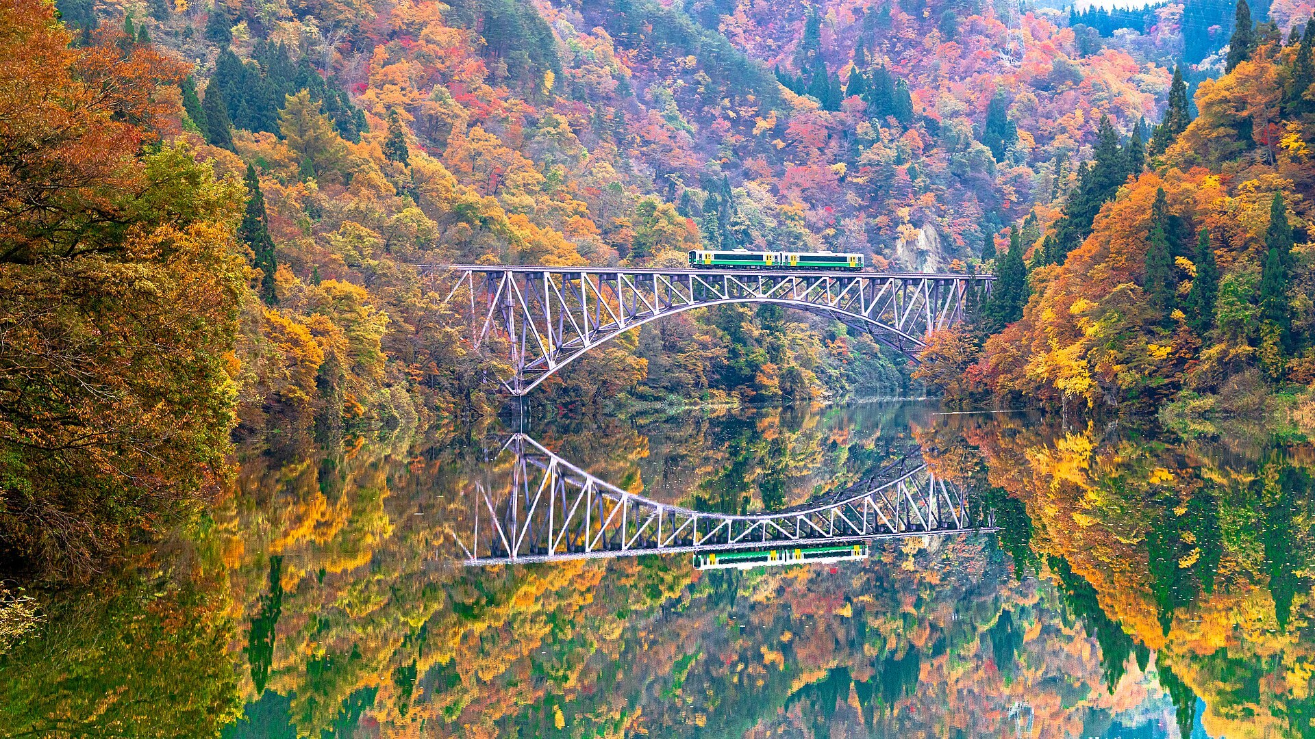 紅葉に包まれた第一只見川橋梁と列車が穏やかな只見川に映る景色